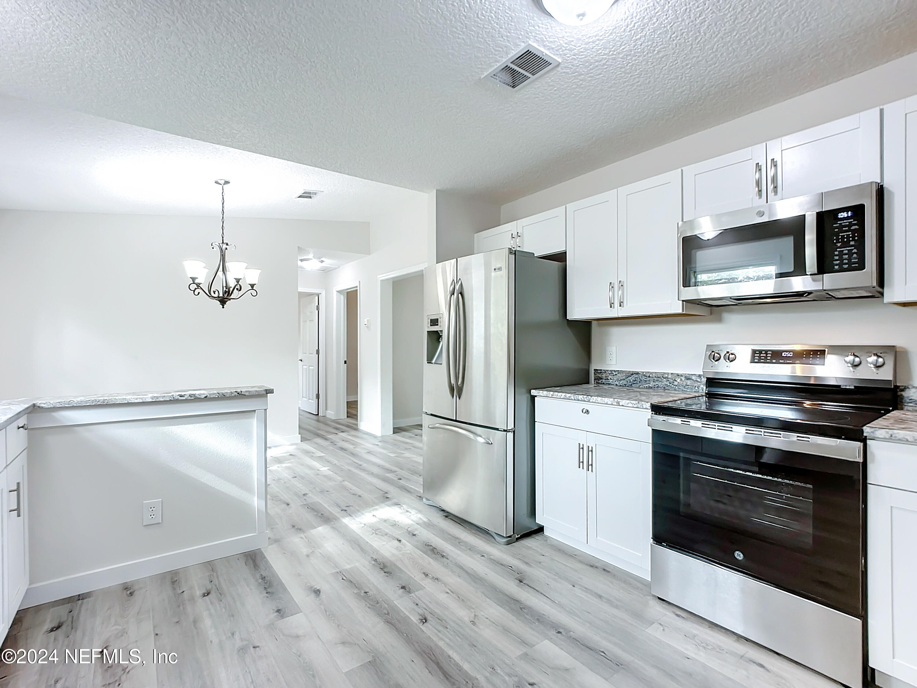 a kitchen with stainless steel appliances a stove microwave and a refrigerator