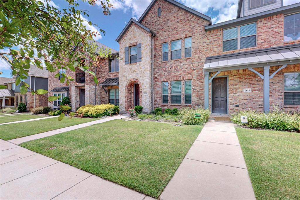 a front view of a brick house with a yard