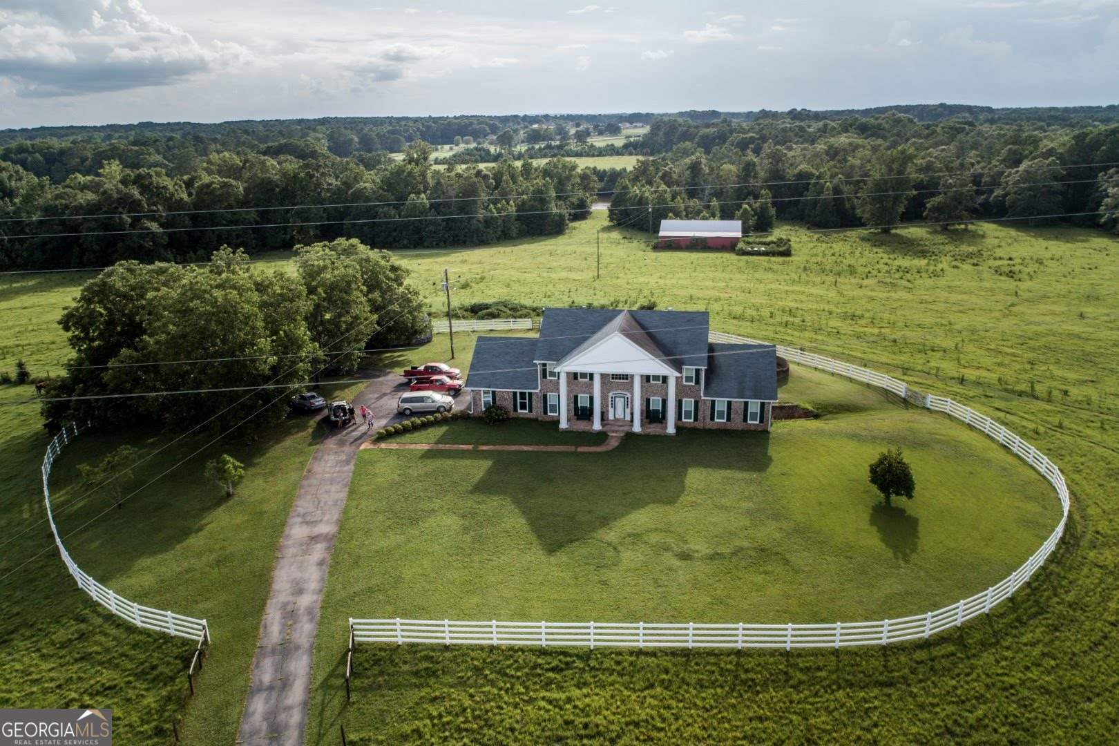 an aerial view of a house with swimming pool and lake view