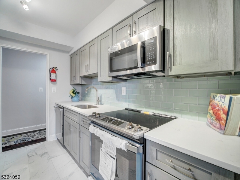 a kitchen with stainless steel appliances granite countertop a sink stove and microwave