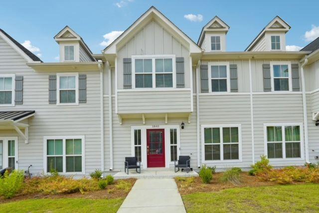 a front view of a house with garden and garage