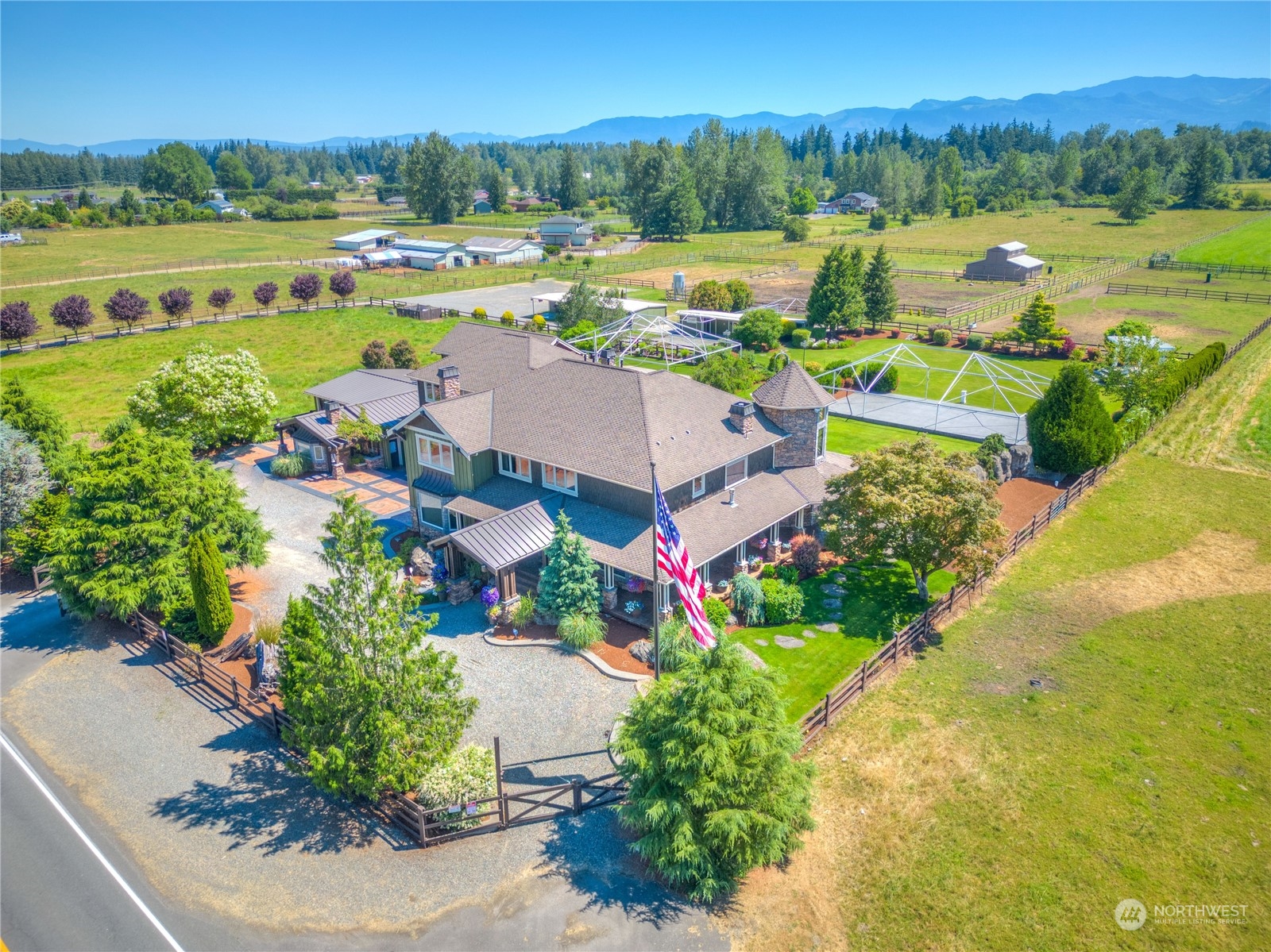 an aerial view of a houses with a garden and lake view