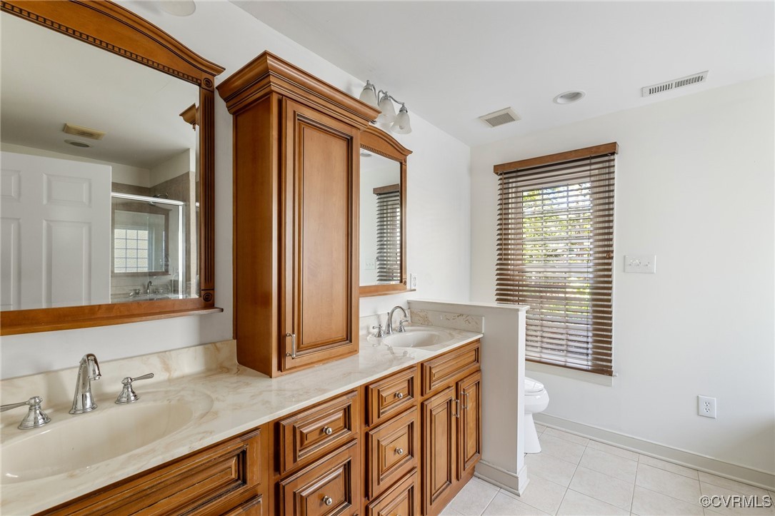 a bathroom with a granite countertop sink and a window