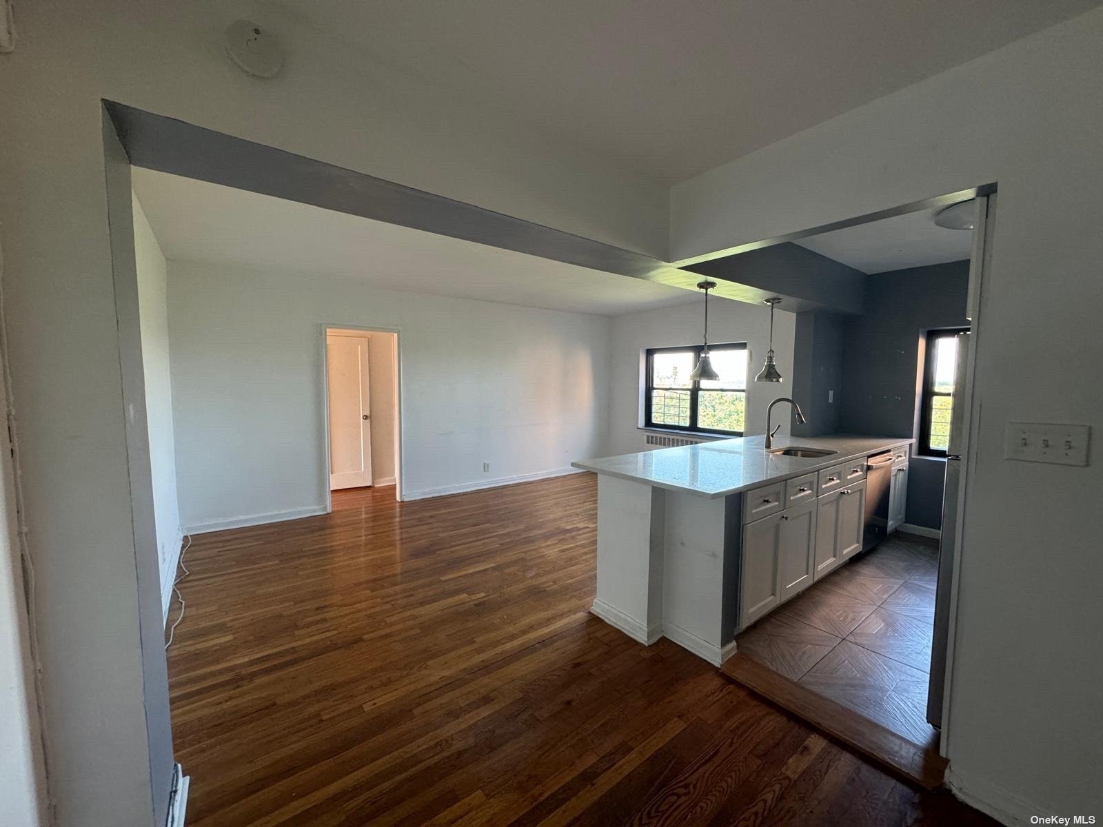 a view of kitchen and hall with wooden floor