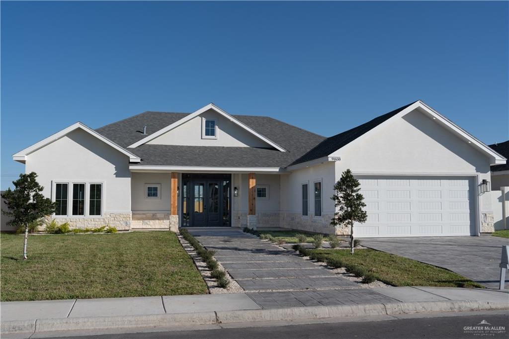 View of front of home with a garage and a front lawn