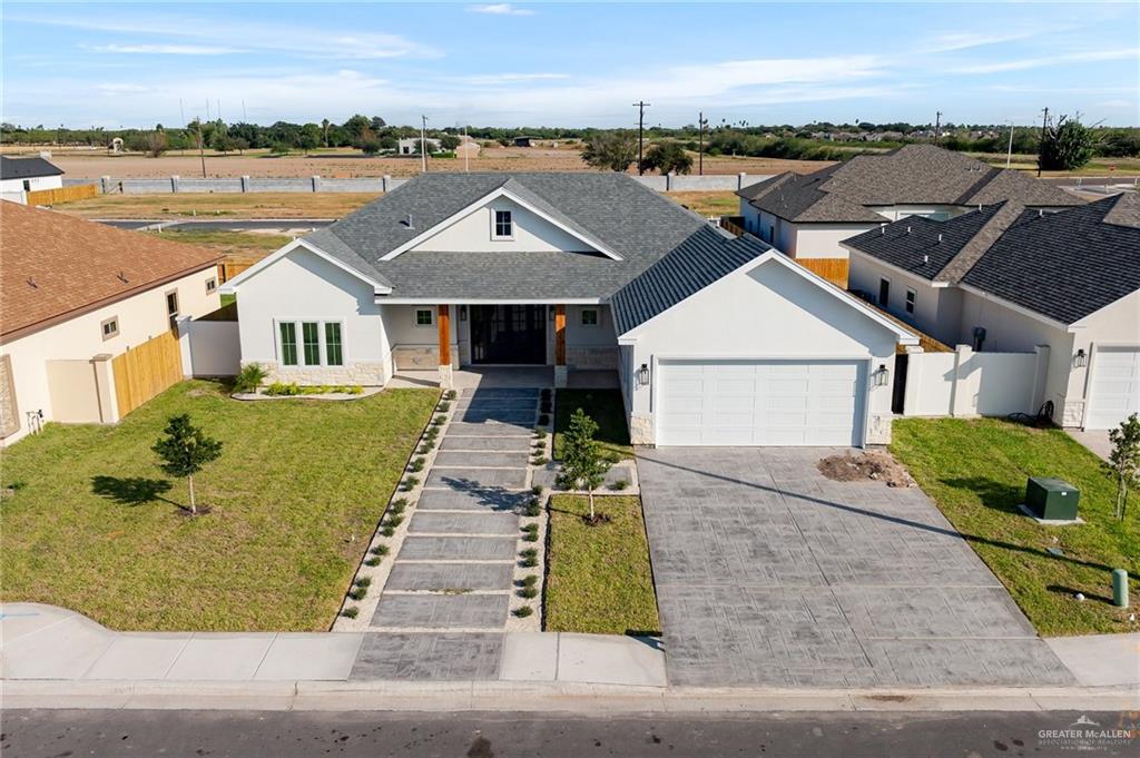 Single story home with a garage and a front lawn