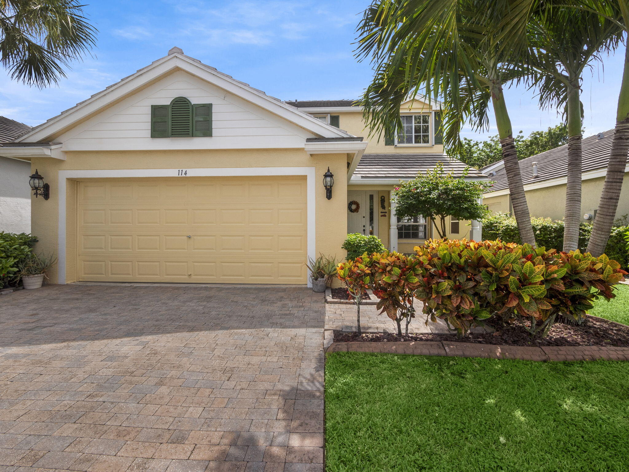 a front view of a house with a yard and a garage