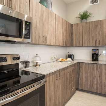 a kitchen with stainless steel appliances granite countertop a stove a sink and a microwave