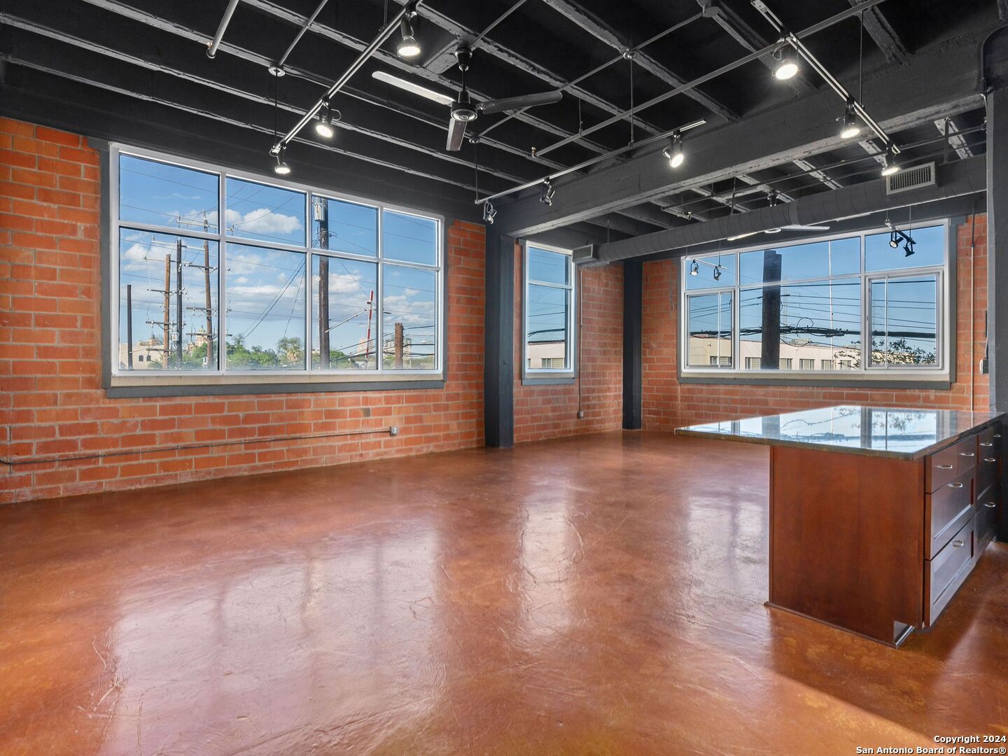 a view of a room with wooden floors and windows