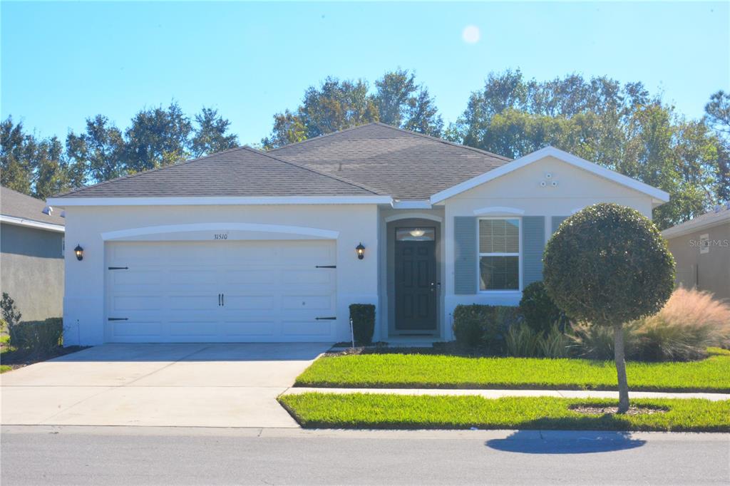 a front view of a house with a yard and garage