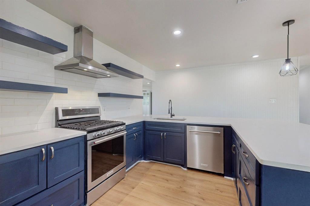 a kitchen with stainless steel appliances granite countertop a stove and a sink