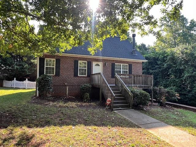 a view of a house with a yard and a tree