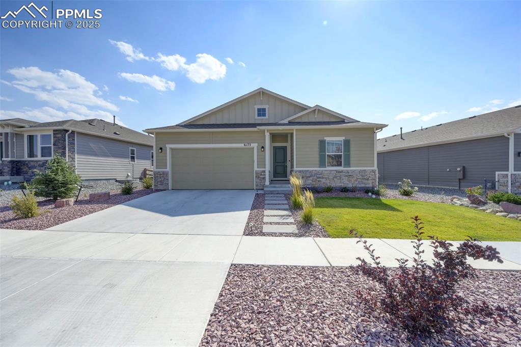 Craftsman-style home featuring a front lawn and a garage