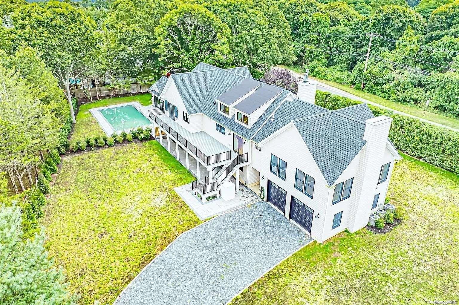 an aerial view of a house with a big yard and large trees