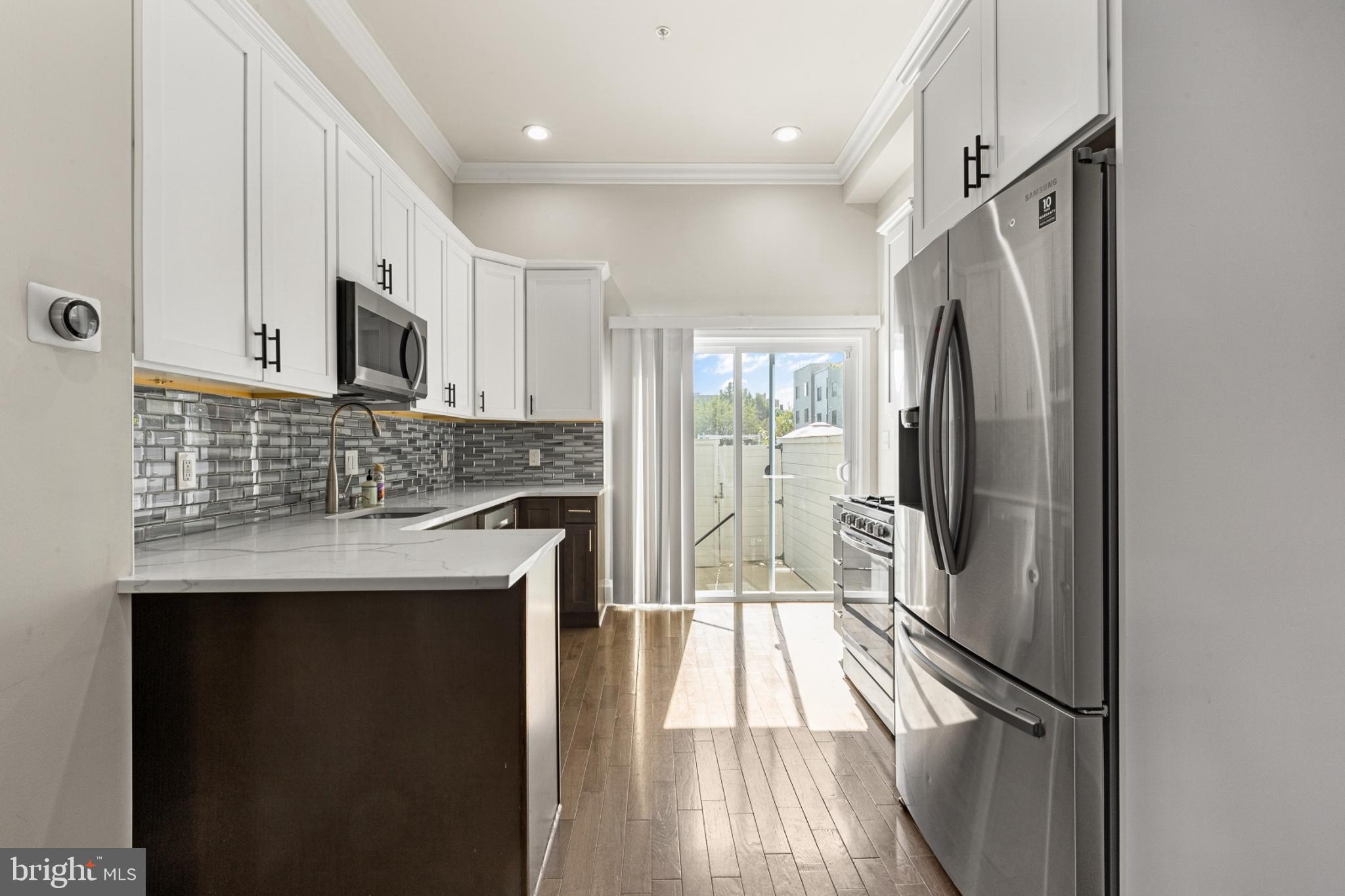 a kitchen with stainless steel appliances granite countertop a refrigerator and a sink