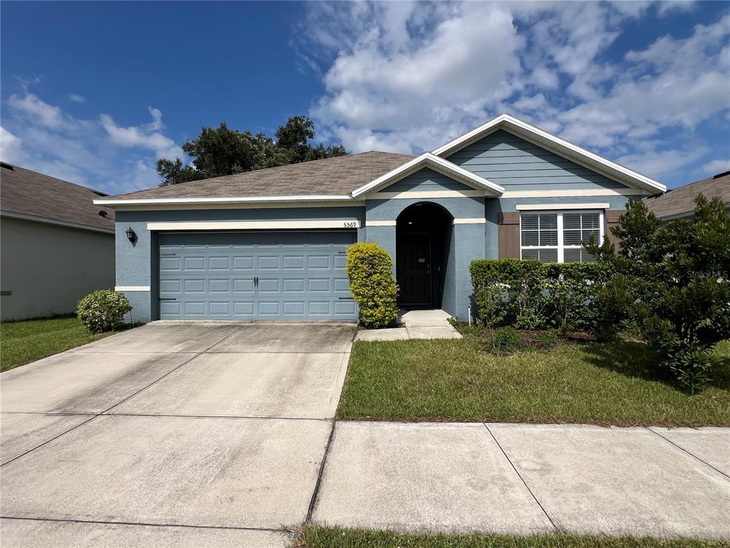 a front view of a house with a yard and garage