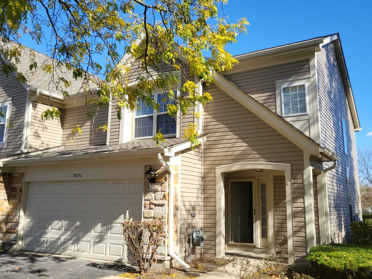 a front view of a house with a tree