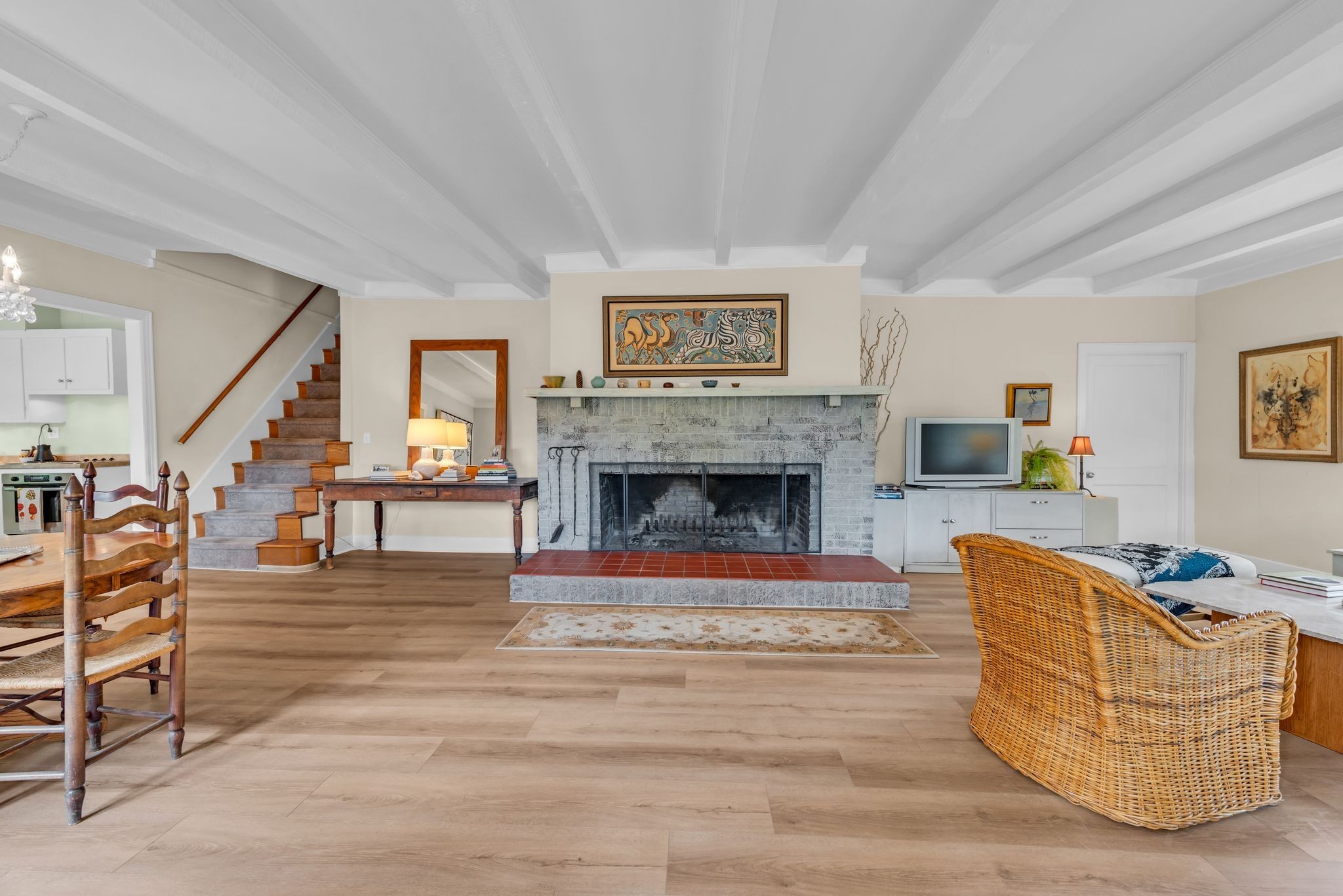 New Solid Plank Flooring spans the Living Room Dining Area and Kitchen   Beamed Ceiling Plus the Largest Fireplace I have ever seen.