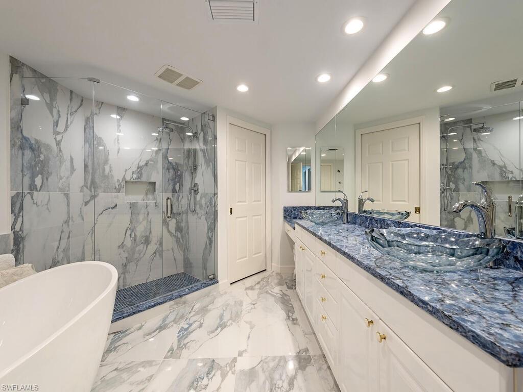 a bathroom with a granite countertop sink a toilet a mirror and shower