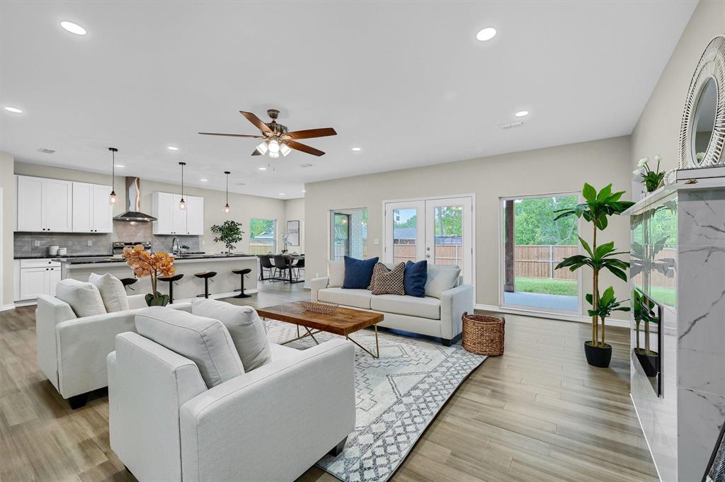 a living room with furniture kitchen view and a potted plant