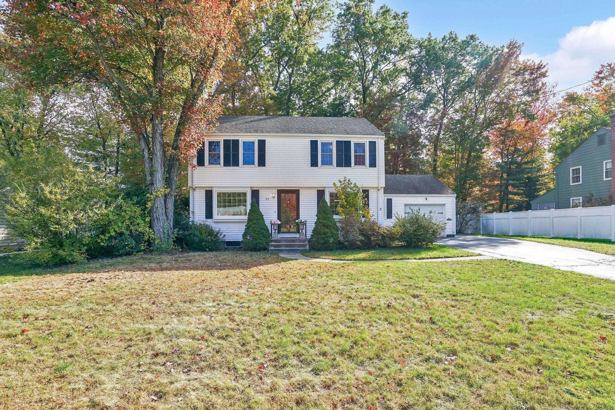 a front view of a house with a yard and trees