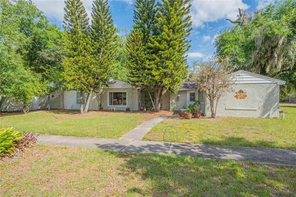 a view of a house with a yard and tree s