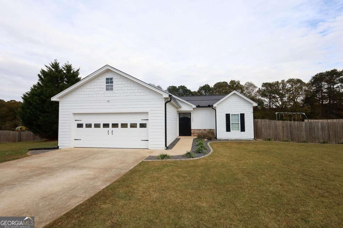 a view of a house with a yard and garage