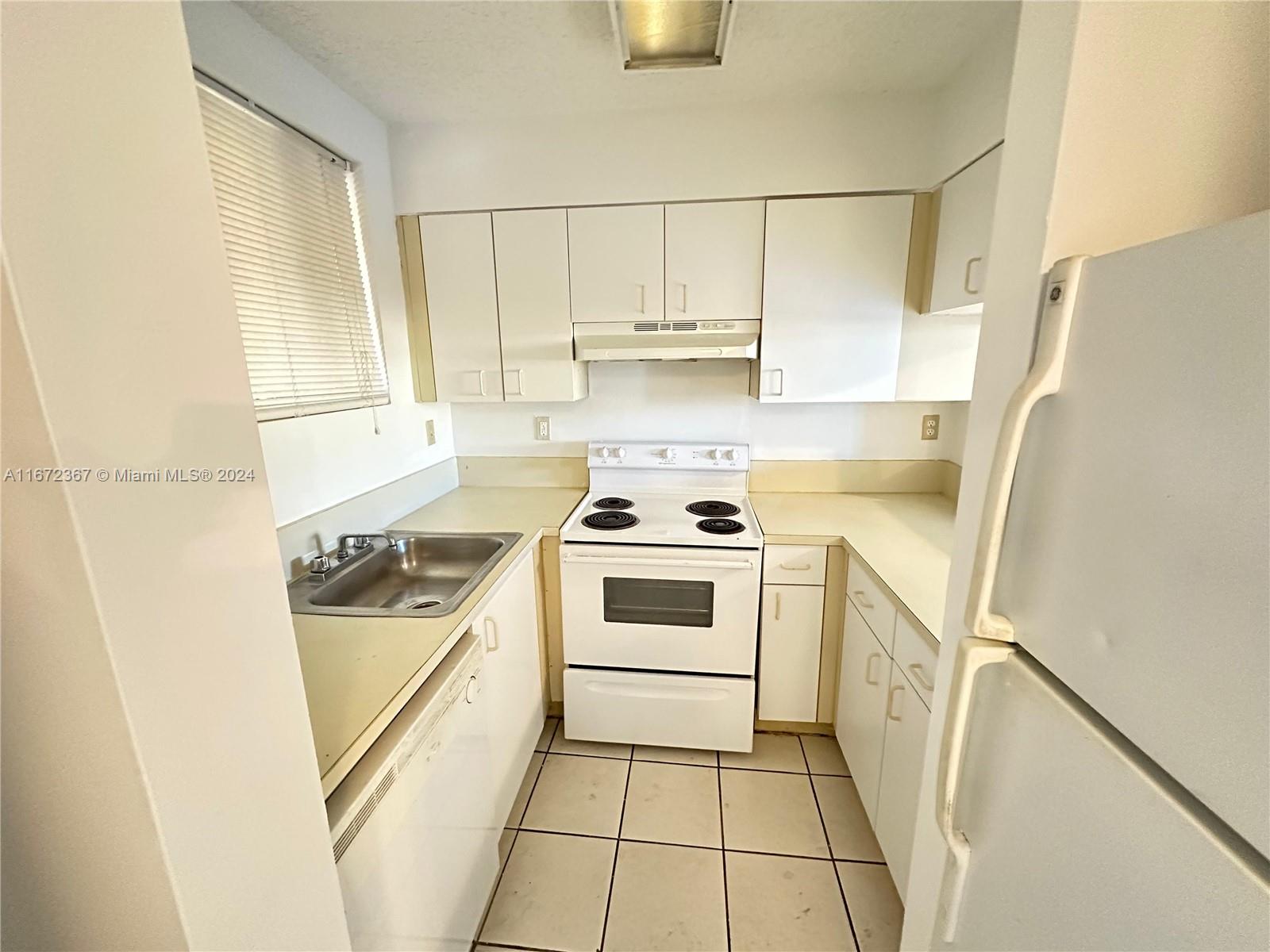 a kitchen with a stove a sink and a refrigerator