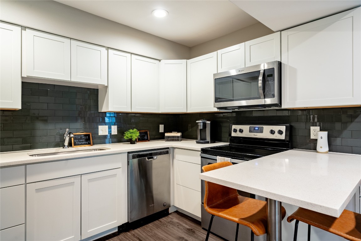 a kitchen with a sink a microwave and cabinets