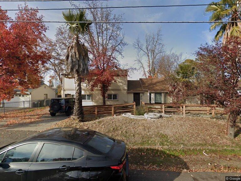 a front view of a house with cars parked