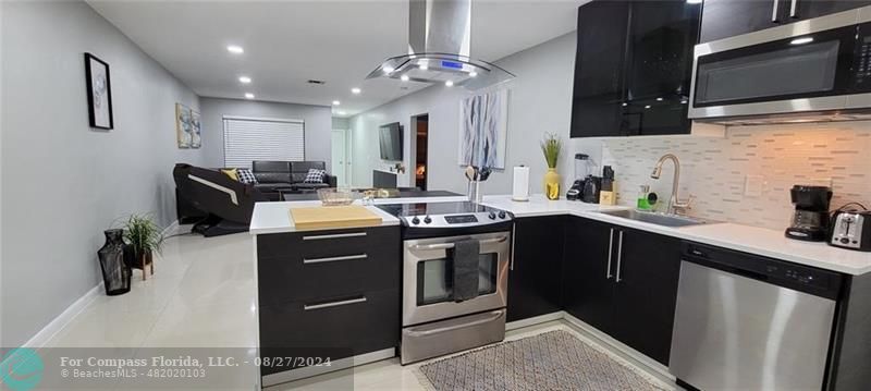 a kitchen with stainless steel appliances granite countertop a sink a stove and a microwave