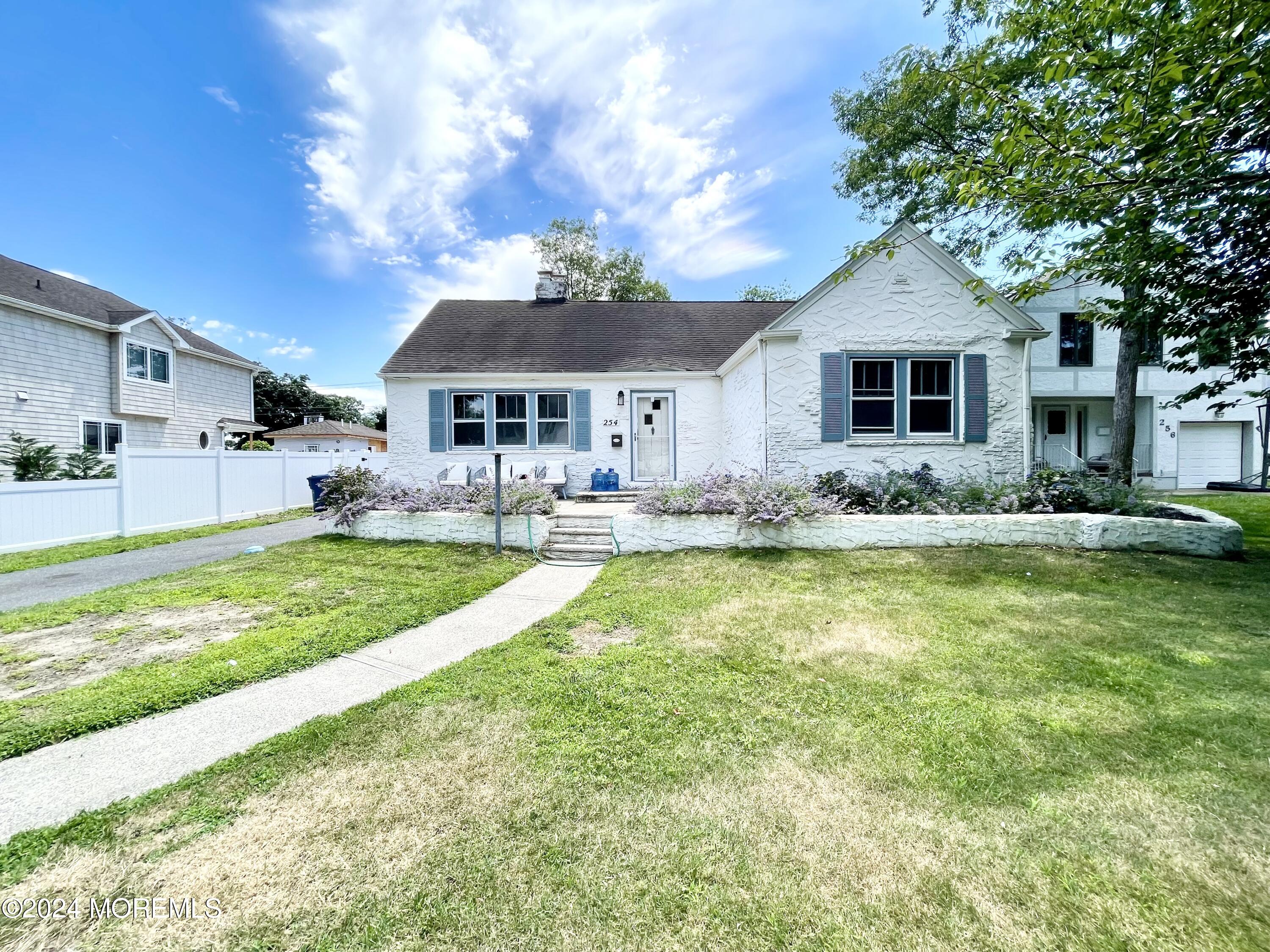 a front view of house with yard and trees around