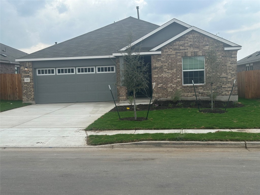 a view of a house with a yard and a garage