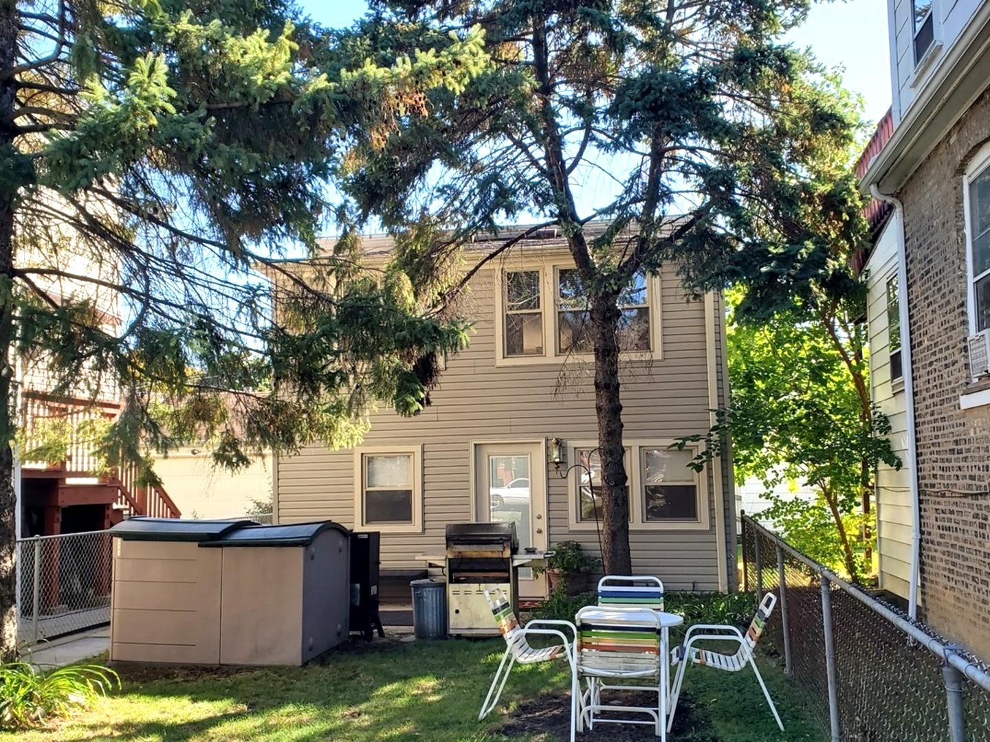 a view of a house with backyard couches and a large tree