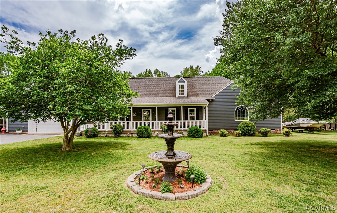 a front view of a house with garden and trees