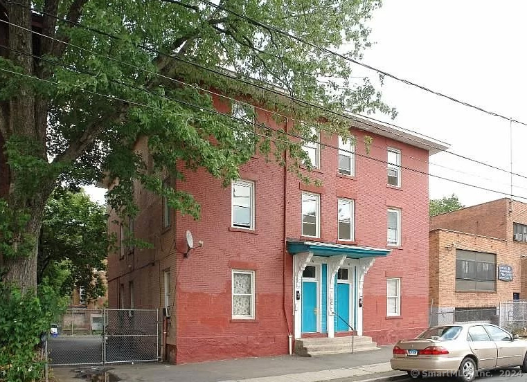 a couple of cars parked in front of brick building