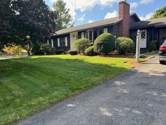 a front view of a house with a yard and potted plants