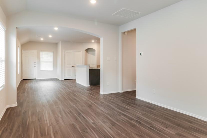 a view of empty room with wooden floor and window