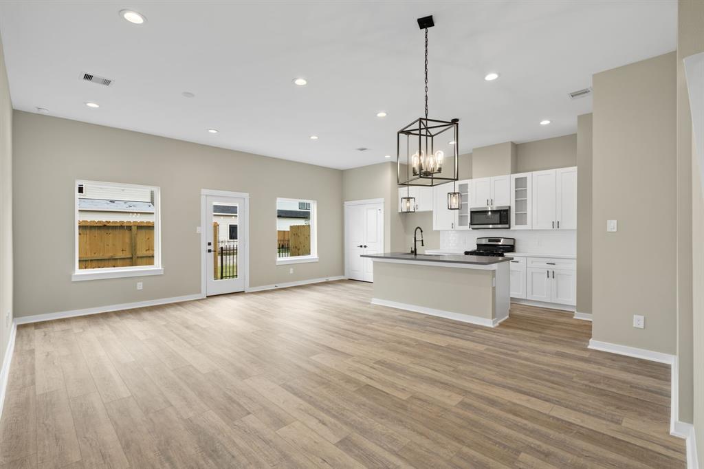 a view of kitchen with granite countertop cabinets and refrigerator