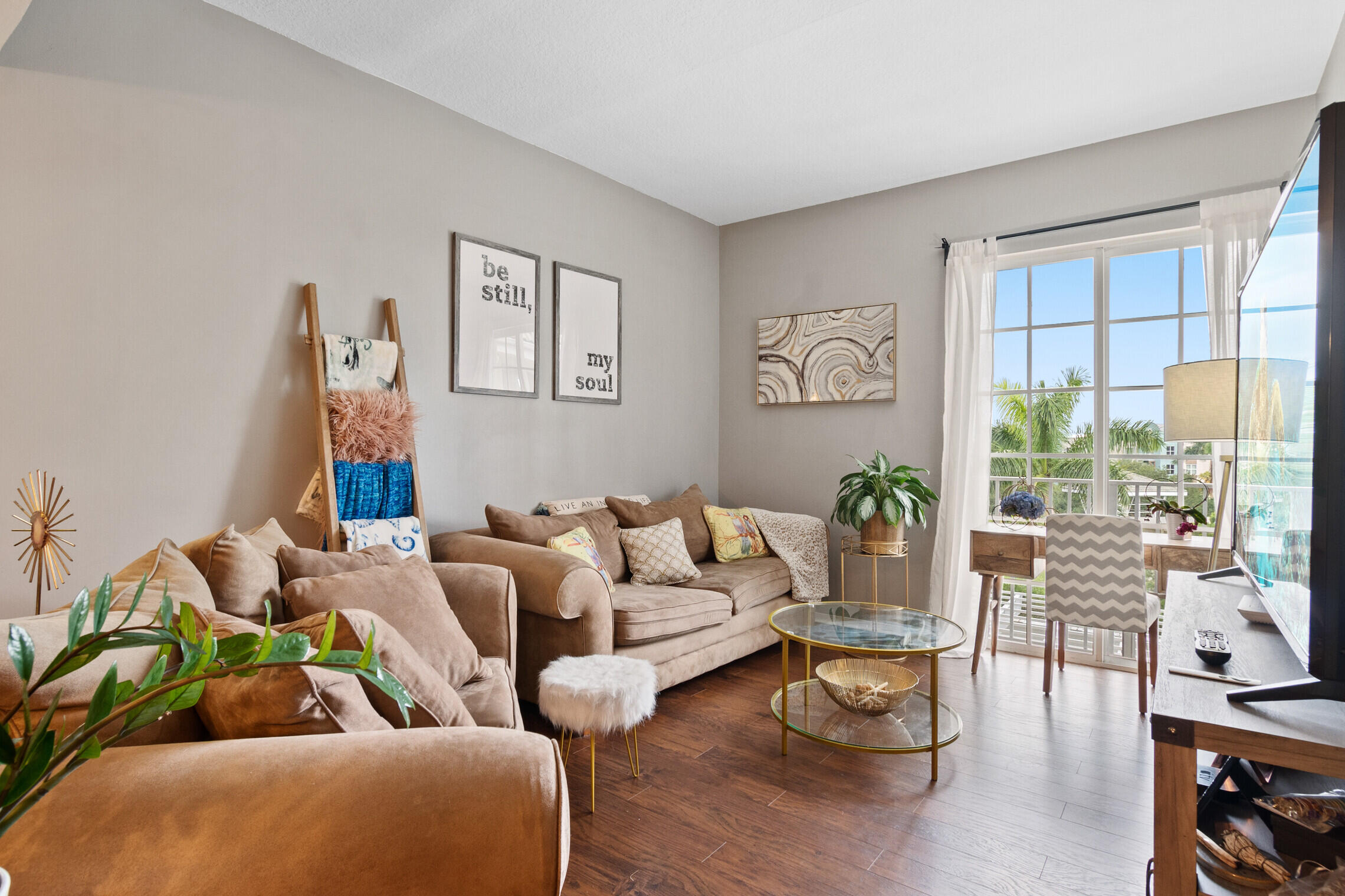 a living room with furniture and floor to ceiling windows