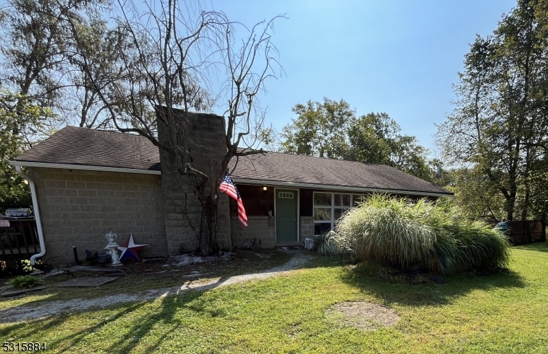 a view of a house with a patio and a yard