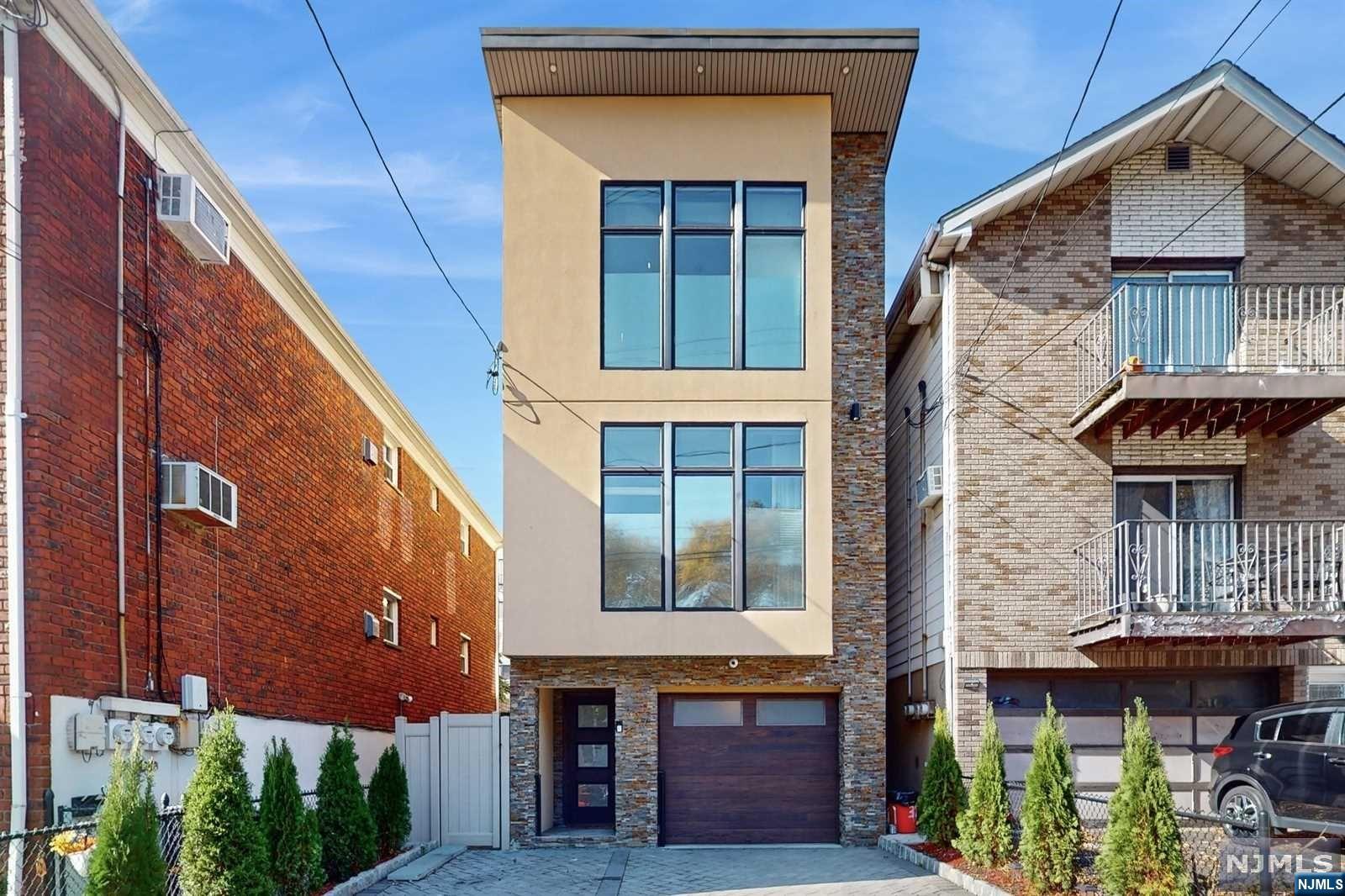 a front view of a building with glass windows and a garage