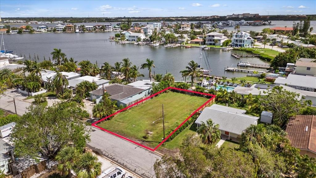 an aerial view of residential houses with outdoor space and lake view