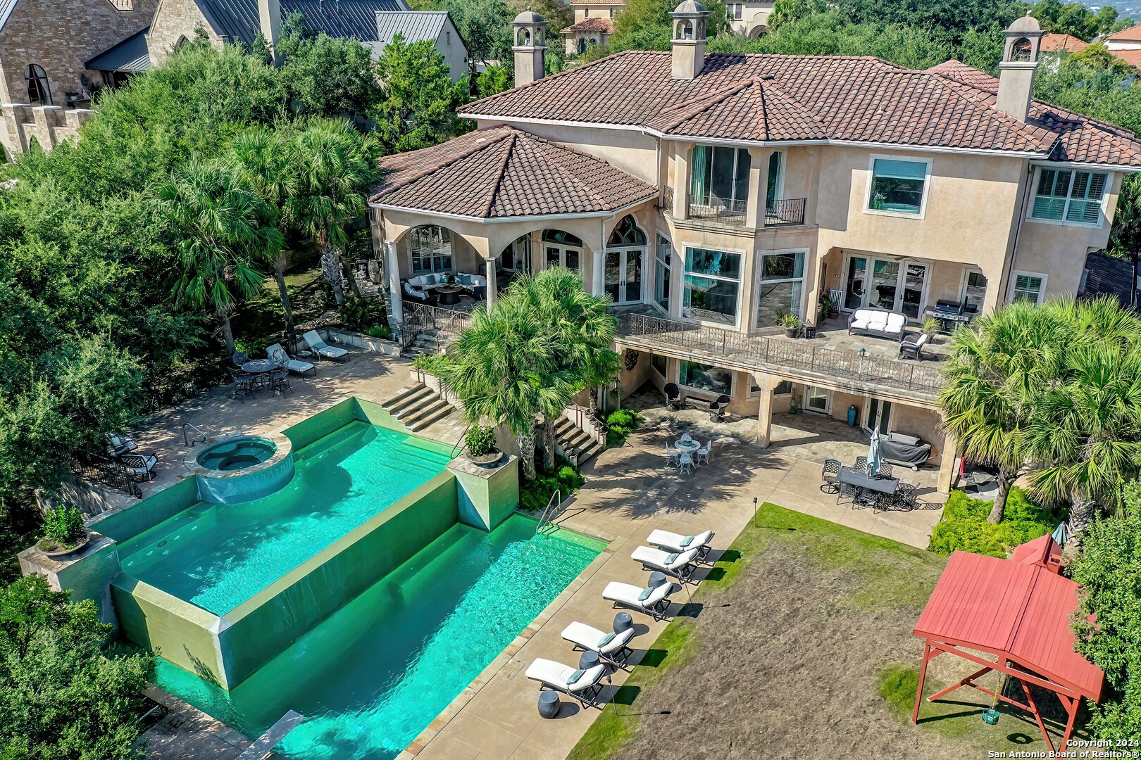 an aerial view of a house with swimming pool garden view and a fire pit