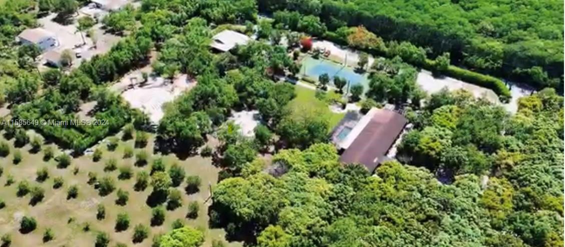 an aerial view of residential house with outdoor space and trees all around