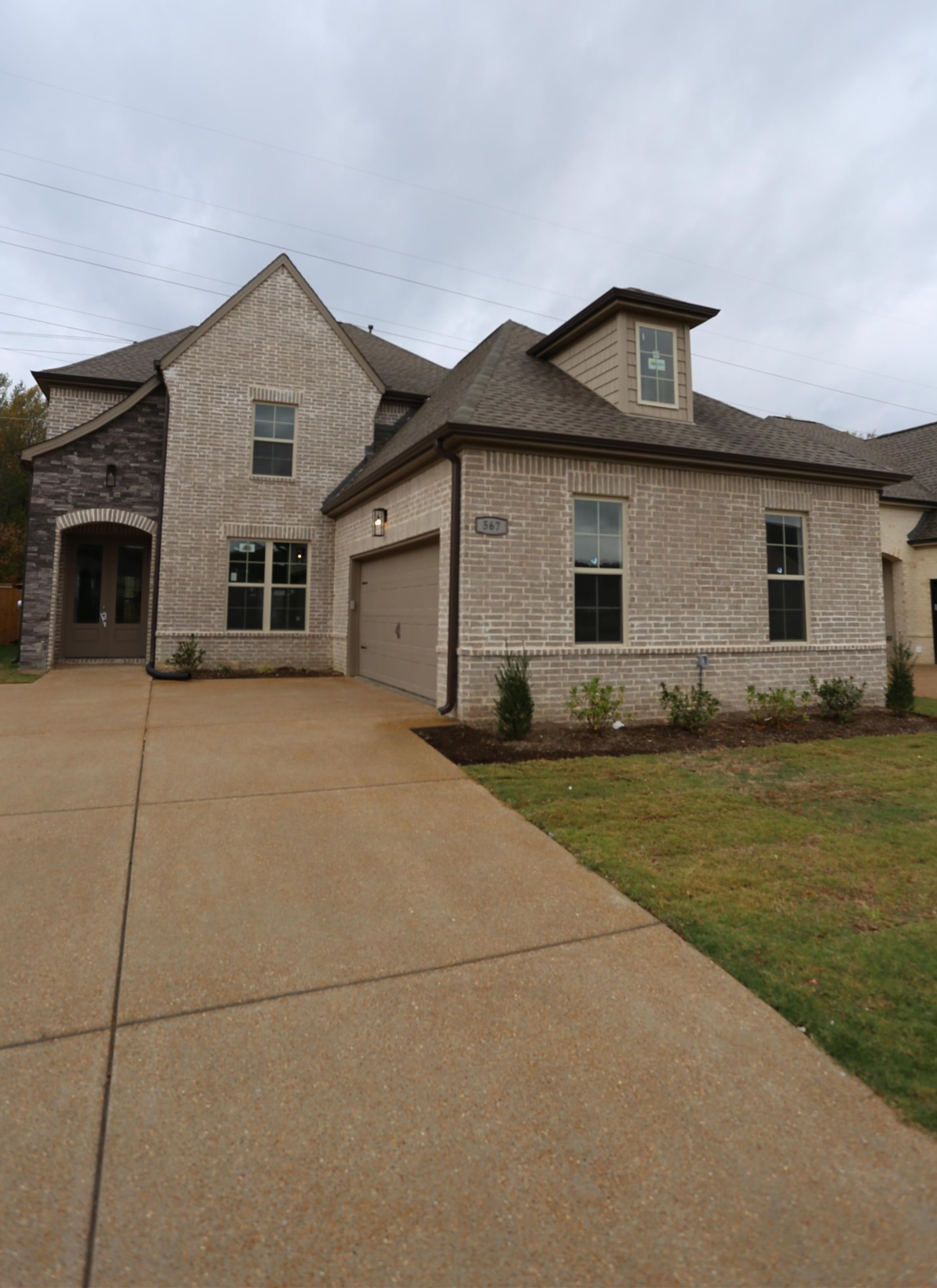 a front view of house with yard and trees in the background