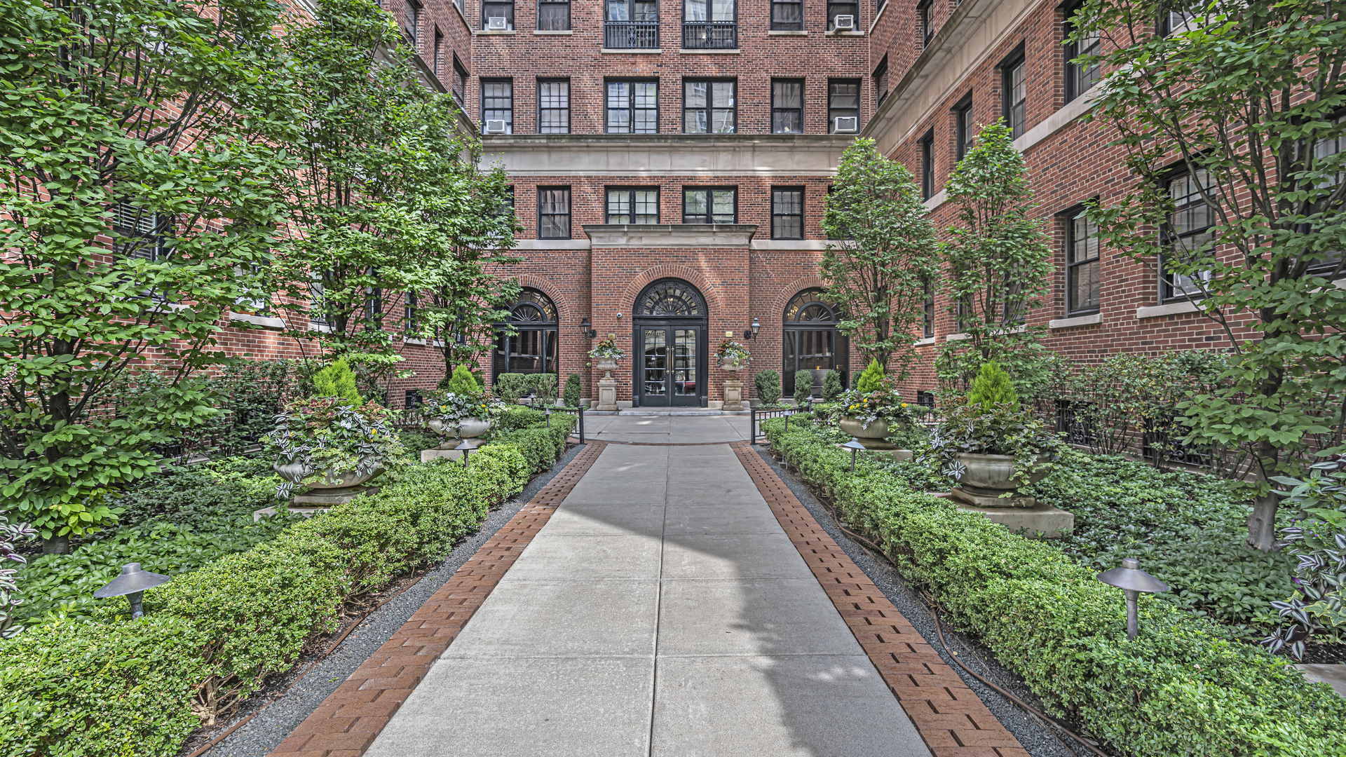 a view of a brick house with potted plants