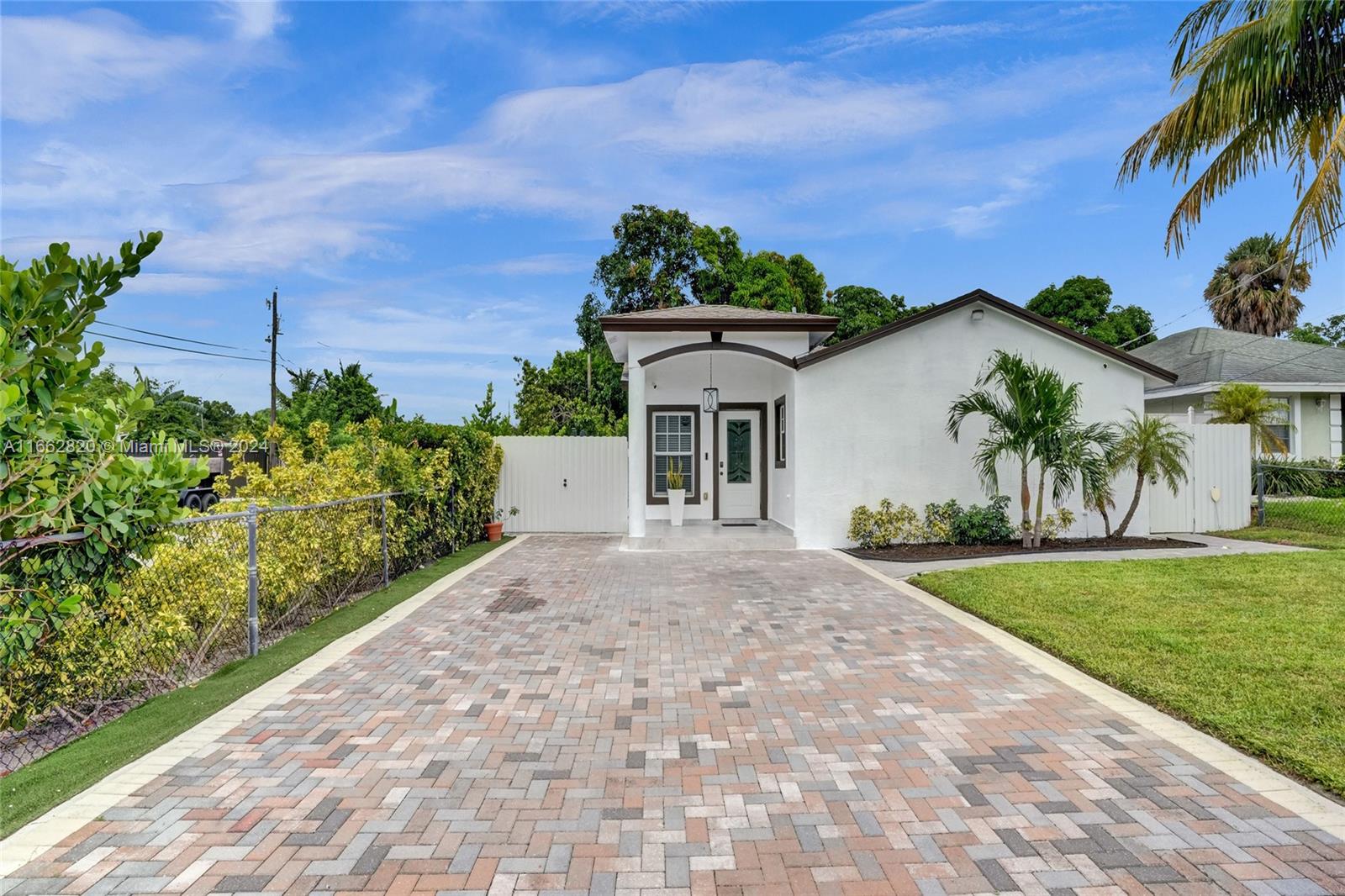 a front view of a house with a yard and potted plants