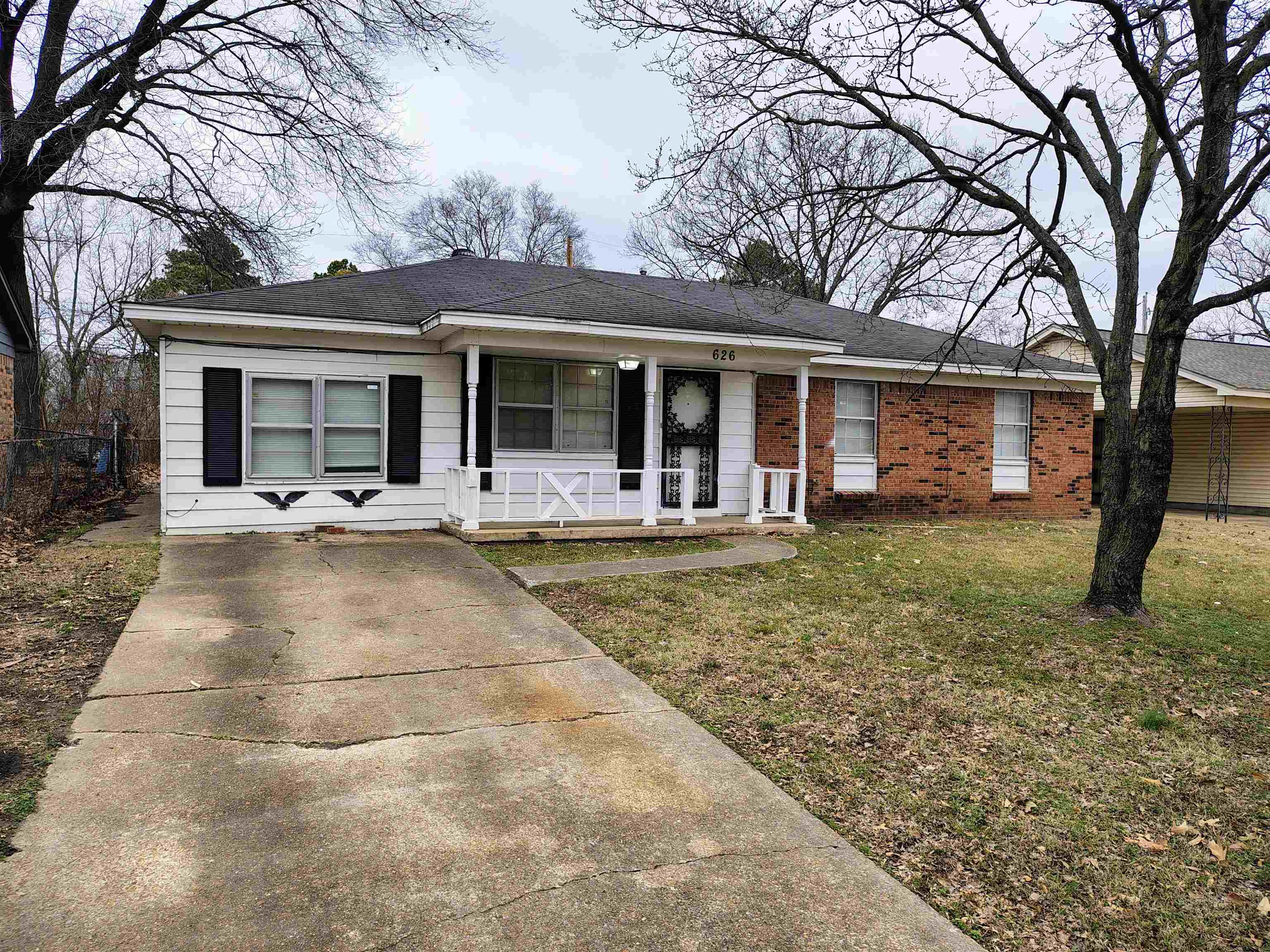 Ranch-style home with covered porch and a front lawn