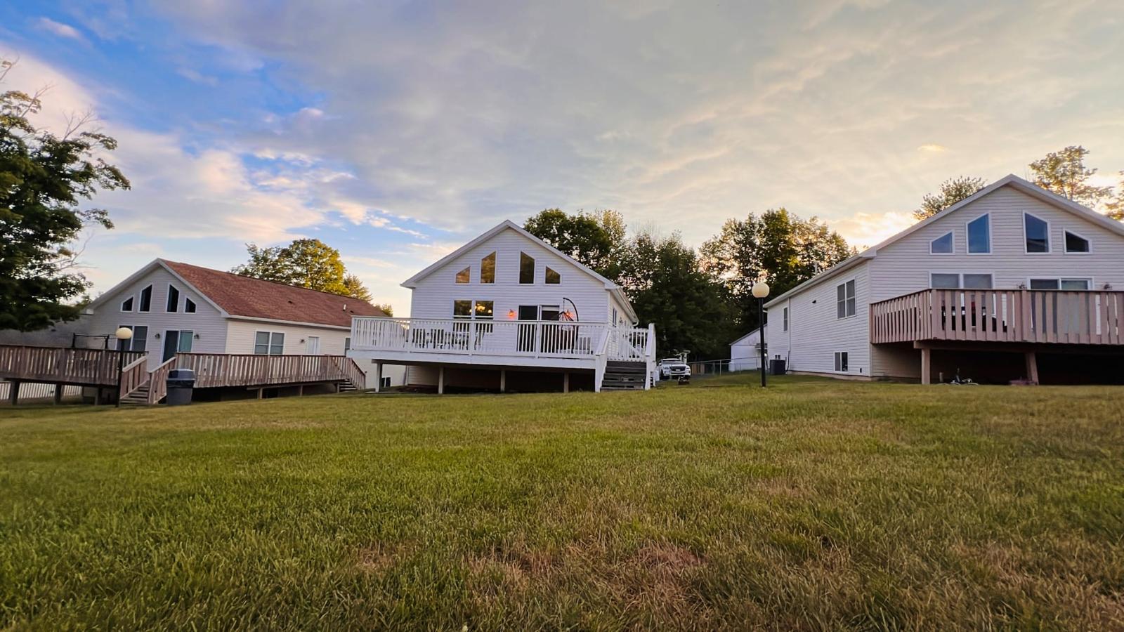 Rear view of property with a lawn and a wooden deck